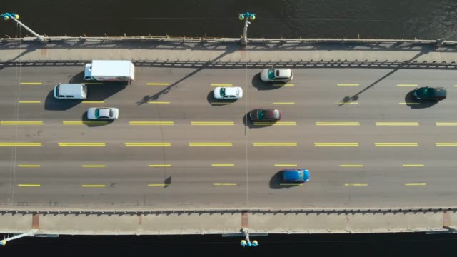 Puente-sobre-el-agua-con-coches-en-movimiento,-vista-de-arriba-hacia-abajo