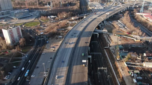 Aerial-view-urban-landscape-high-speed-road-with-moving-cars-on-a-beautiful-sunny-day.-Shot-from-drone