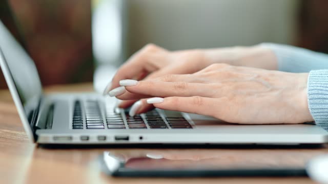 Female-hands-typing-on-keyboard-of-laptop-pc-working-side-view.-Close-up-shot-on-4k-RED-camera