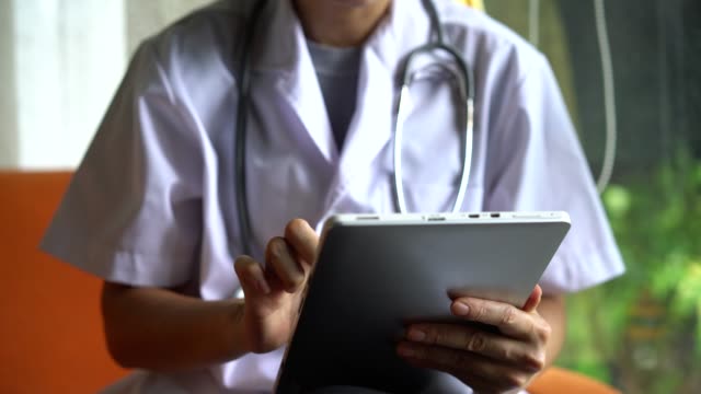Médico-de-mano-que-utiliza-tableta-digital-para-el-tratamiento-en-línea