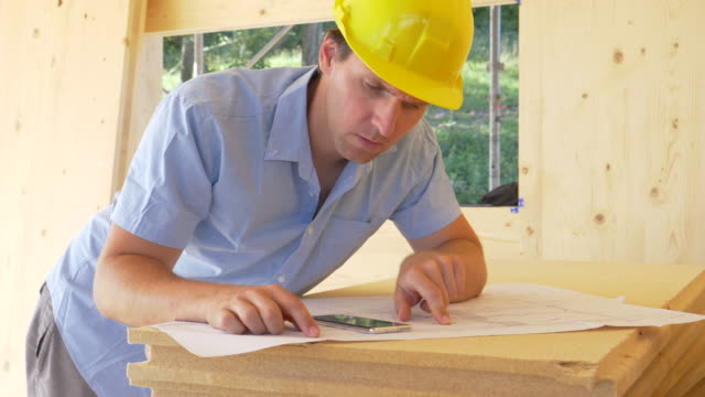 CLOSE-UP:-Construction-site-overseer-shakes-his-head-while-looking-at-plans.