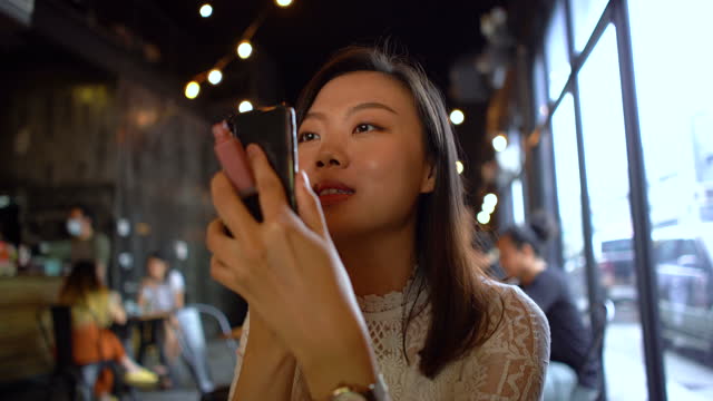 Junge-asiatische-Frau,-die-Lippenstift-mit-Smartphone