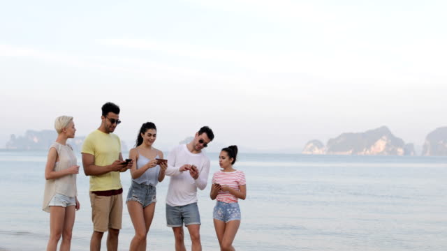 Menschen-zu-Fuß-am-Strand,-im-Gespräch-mit-Smart-Phones,-junge-Touristen-Zellgruppe-Networking-Online