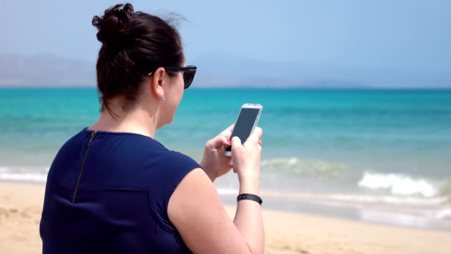 Video-de-mujer-comprobar-sus-e-mails-en-el-teléfono-móvil-en-las-vacaciones-en-4k