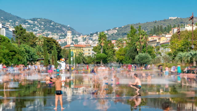 Personas-a-pie-en-un-timelapse-de-park-Promenade-du-Paillon,-famoso-por-sus-fuentes-planas-en-Niza,-Francia