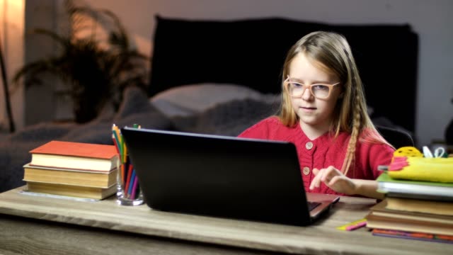 Lächelnde-Schulmädchen-net-surfen-am-Laptop-zu-Hause