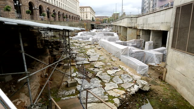 Ancient-ruins-excavated-in-middle-of-street-surrounded-by-monumental-buildings