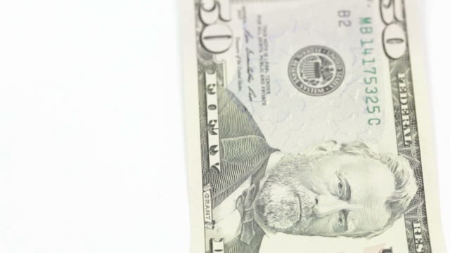 Fallende-Geld,-hundert-Dollar-Scheine-auf-und-fünfzig-Dollar-Scheine-auf-weißem-Hintergrund.