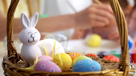 Happy-Easter!-Mother-and-her-little-daughter-wearing-funny-rabbit-ears-coloring-easter-eggs