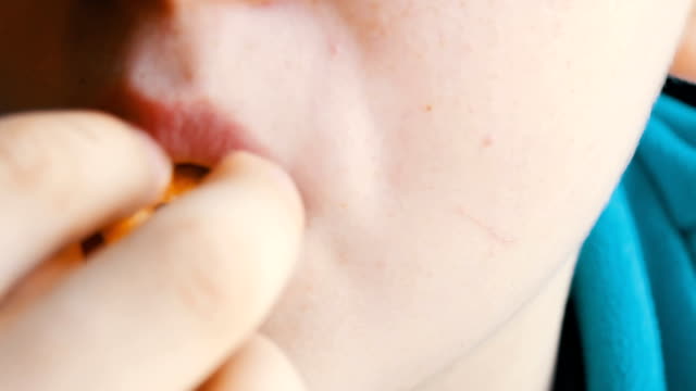 Close-up-view-of-teenager's-mouth.-A-boy-with-an-appetite-is-eating-a-french-fries-in-a-fast-food-restaurant