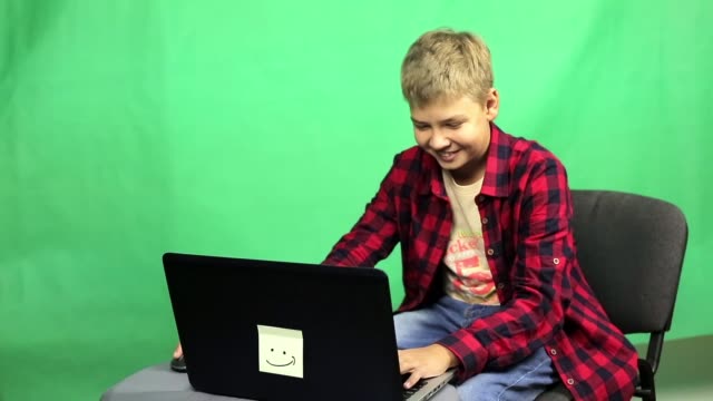 Young-boy-blogger-records-video-on-a-green-background