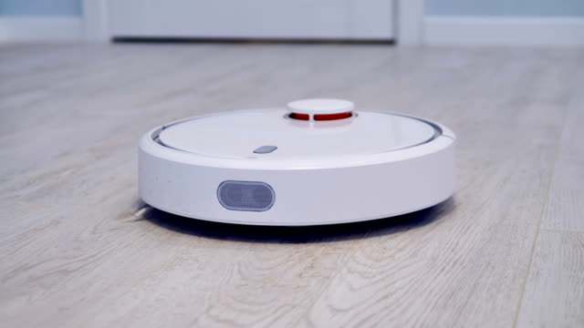A-robotic-vacuum-cleaner-works-on-a-laminate-flooring.
