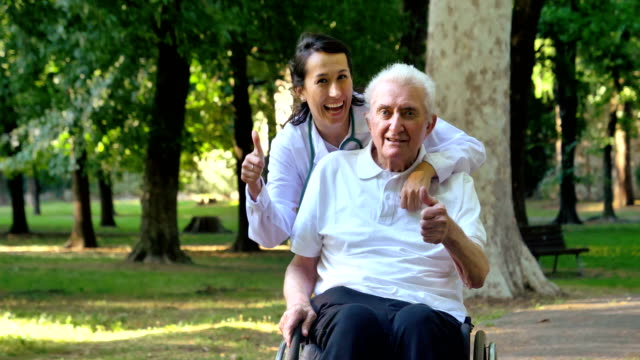 Arzt,-Krankenschwester,-Pflege-für-ältere-Menschen,-Mädchen-(Frau)-und-Großvater-in-einem-Rollstuhl-sitzt-im-Park-spazieren.