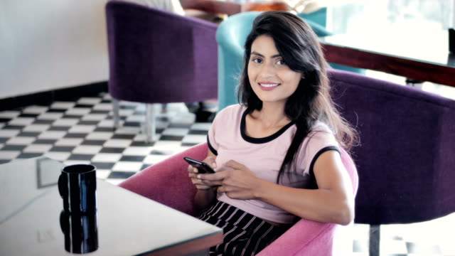 Ein-schönes-Mädchen-sitzen-in-einem-Café-mit-smartphone