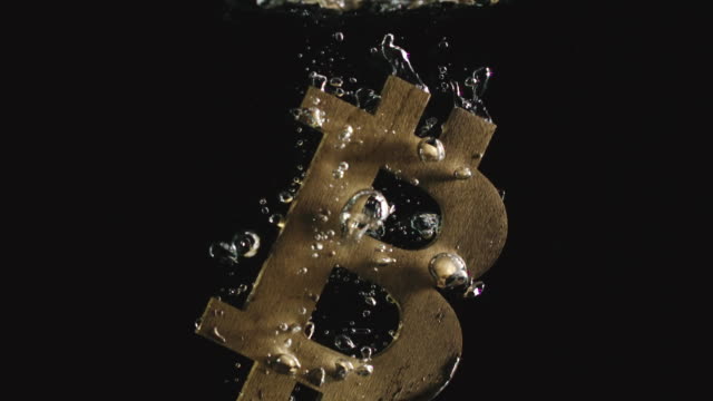 Zeitlupe:-Golden-Bitcoin-Symbol-fällt-ins-Wasser