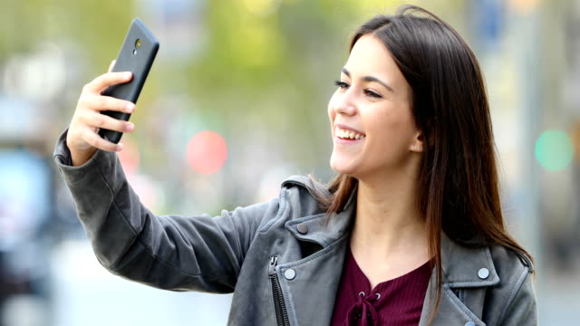 Happy-teen-having-a-video-call-in-the-street