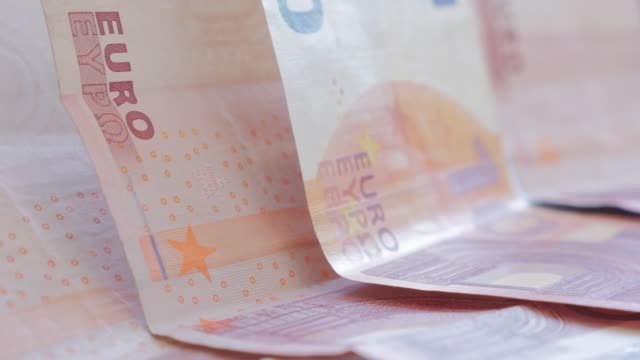 European-monetary-union-paper-banknotes-arranged-slow-tilt-4K-2160p-UltraHD-footage---Euro-10-paper-bills-on-the-table-slow-tilting-4K