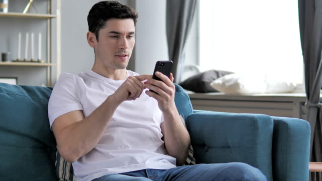 Young-Man-Excited-for-Success,-Winning-Online-on-Smartphone