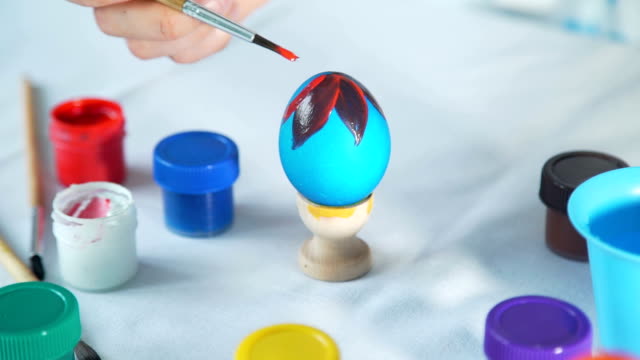 Mujer-mano-pintura-huevo-de-Pascua-con-pincel