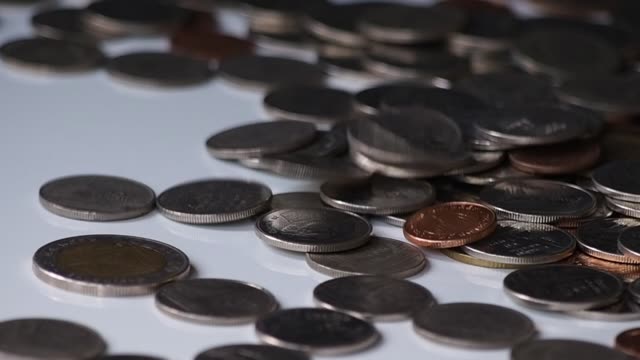 close-up-slow-motion-footage-of-money-coins-falling-to-pile-of-coins-on-white-floor.-business,-financial-for-money-saving-or-investment-concept