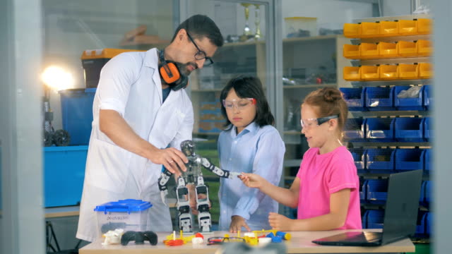 Ingenieur-mit-Schulkindern-studiert-innovative-Robotertechnologien-im-Science-Club.
