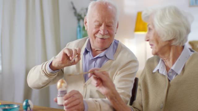 Feliz-pareja-de-ancianos-pintando-huevos