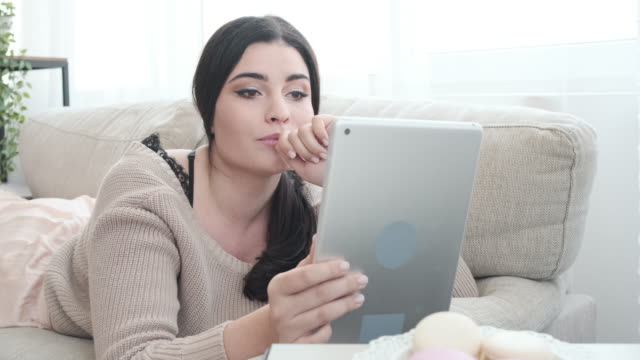 Entspannte-Frau-mit-digitalem-Tablet-auf-Sofa