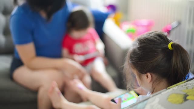 Familia-multirracial-que-recibe-tiempo-de-pantalla-viendo-contenido-en-teléfonos-celulares