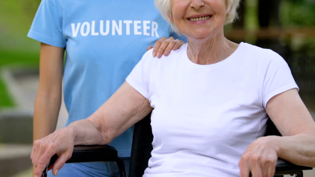 Voluntario-sosteniendo-la-mano-en-el-hombro-de-la-mujer-discapacitada,-apoyo-de-las-personas-discapacitadas