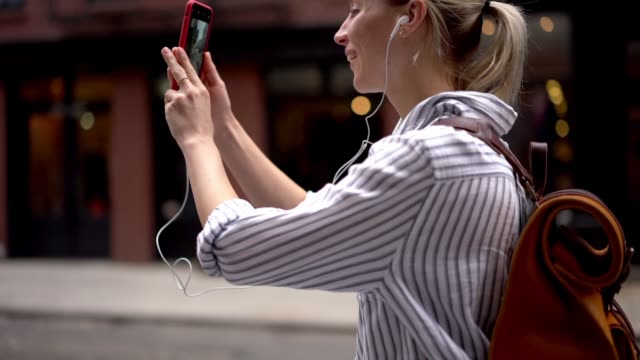 Zeitlupeneffekt-von-fröhlichen-Hipster-Mädchen-in-elektronischen-Kopfhörern-suchen-Kontakt-in-sozialen-Netzwerken