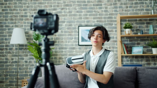 Teenage-boy-spricht-über-ar-Brille-Aufnahme-Video-für-Online-Vlog-zu-Hause