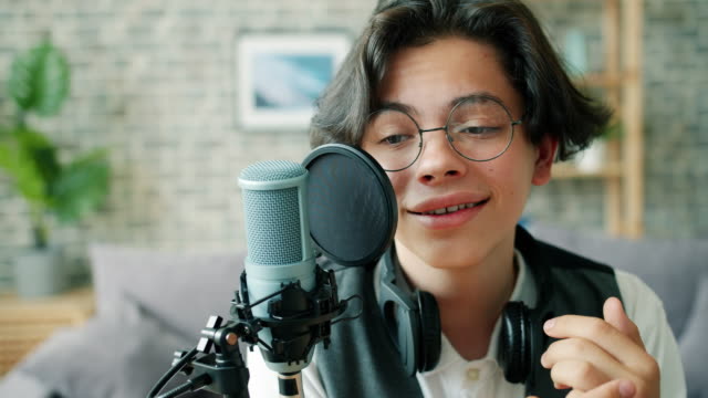 Nahaufnahme-von-glücklichen-Jungen-sprechen-in-Mikrofon-Aufnahme-Podcast-für-Blog