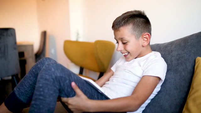 Junge-spielt-Spiele-auf-seinem-Tablet-zu-Hause