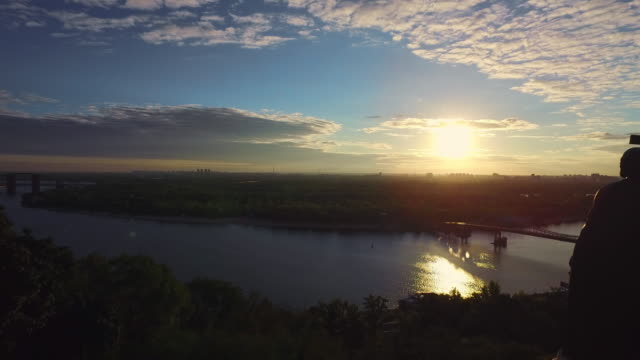 Silhouette-Prince-Vladimir-holding-cross-in-evening-Kiev-aerial-landscape