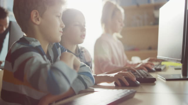 Elementary-School-Computer-Science-Classroom:-Portrait-of-Smart-Girl-and-Boy-Talking-while-using-Personal-Computer,-Learning-Informatics,-Internet-Safety,-Programming-Language-for-Software-Coding