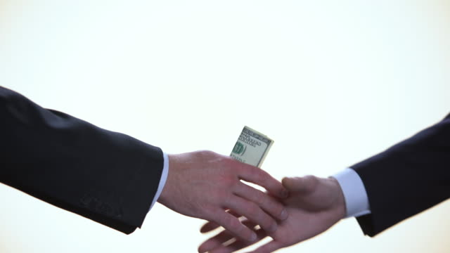 Faceless.White-background.--Close-up.-Businessmen--making-a-deal-with-a-bribe