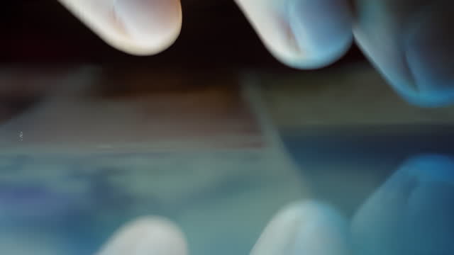 Close-up-Macro-Man-Browsing-Tablet-Computer-With-Finger.-Person-Using-Smartphone,-Browsing-through-Pictures-on-Social-Network-Wall.-Close-Up-Finger-Scrolling-Social-Media-App-Feed.