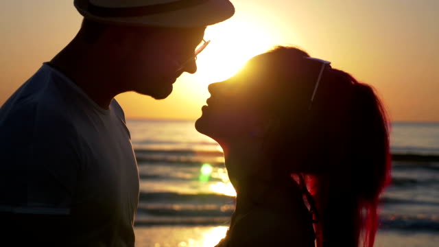 Beautiful-young-couple-teasing-one-another-and-kissing-at-sunset