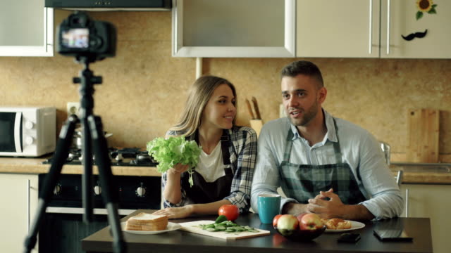 Junges-attraktives-Paar-shooting-video-Lebensmittel-Blog-über-das-Kochen-auf-Dslr-Kamera-in-der-Küche