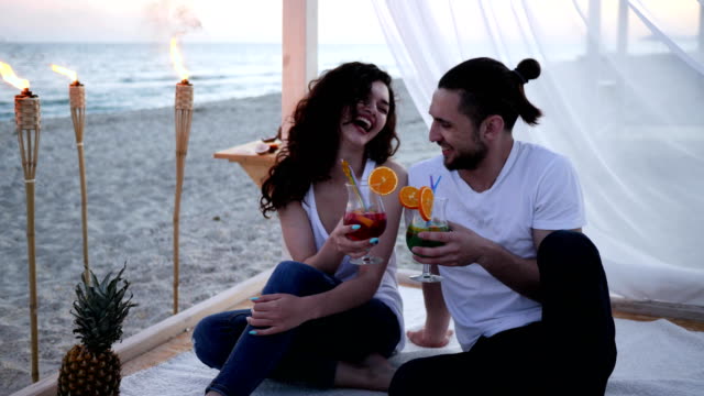 Sommerurlaub,-junge-Menschen-in-der-Liebe-trinken-bunten-Cocktails-mit-Obst,-romantisch-zu-zweit-am-tropischen-Strand