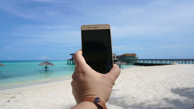 Toma-POV-de-un-teléfono-inteligente-tomar-foto-en-la-mano-del-turismo.-Divertirse-en-vacaciones-mar