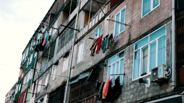 Große-Anzahl-von-gewaschenen-Wäsche-hängt-an-einem-Seil-und-trocknet-auf-der-Straße-neben-dem-Haus