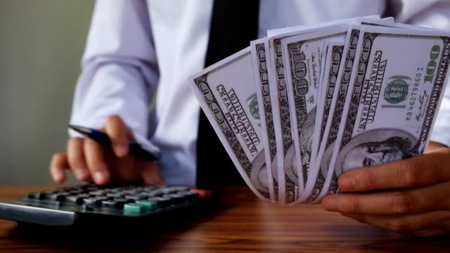 businessman's-hands-counting-hundred-dollar-bills