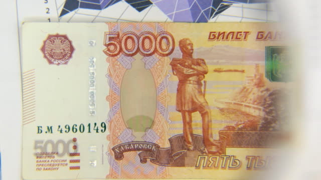 Betrachten-Sie-eine-Banknote-von-fünf-Tausend-Rubel,-eine-Erhöhung-mit-einer-Lupe