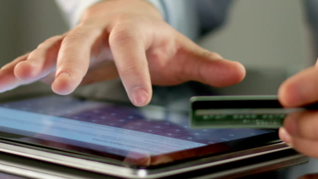 Des-Mannes-hand-einfügen-Kartennummer-auf-Tablet-PC,-Person-zahlt-Rechnungen-online