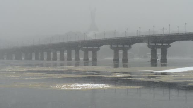 Blick-auf-die-Paton-Brücke-im-Winter.-Schneefall-in-Kiew-in-der-Nähe-des-Dnjepr.