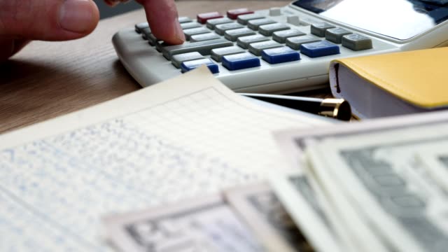 Businessman-using-calculator-and-accounting-book-for-financial-calculations.