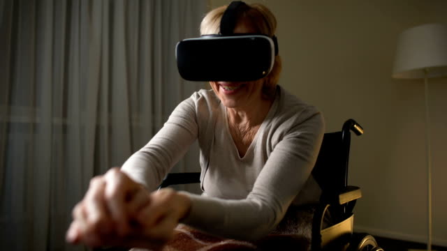 Aufgeregt,-ältere-Dame-im-Rollstuhl-Spaß-in-modernen-virtual-Reality-Kopfhörer