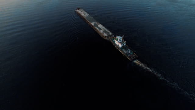 Schiff-fährt-entlang-des-Flusses-in-der-Nähe-der-Stadt-Port-auf-Sonnenuntergang-Luftaufnahmen