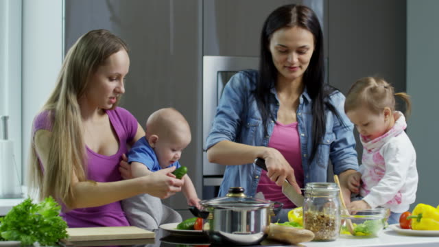 Weibliche-Ehepaar-mit-Kindern-machen-Salat-und-im-Chat